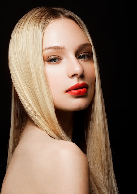 Beauty fashion model portrait with shiny blonde hairstyle with red lips on black background