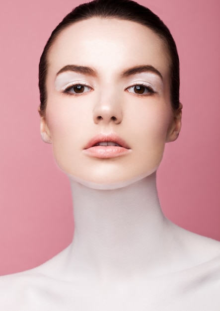 Beauty fashion model with white skin makeup on pink background