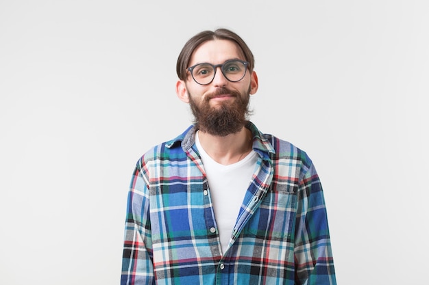 Beauty, fashion and people concept - Portrait of a young bearded hipster stylish guy over white