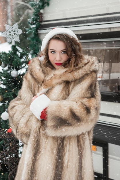 Beauty girl in fur coat at winter campsite getting ready for the new year