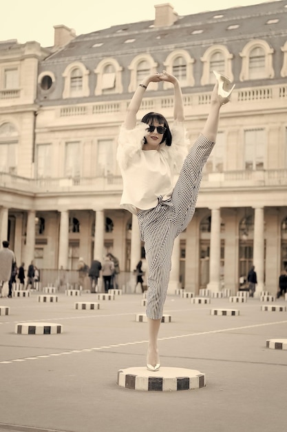 Beauty girl with glamour look Sensual woman with brunette hair Woman pose on high heel shoes in paris france Fashion model in sunglasses on square Fashion and vogue Yoga and sport concept