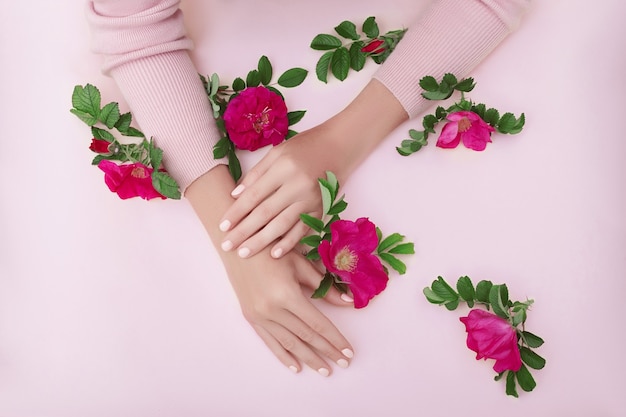 Beauty Hand of a woman with red flowers lies on table