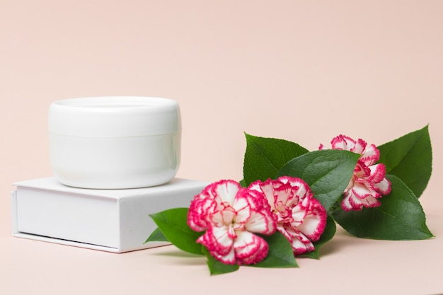 Beauty industry concept White cosmetic cream jar top with flowers