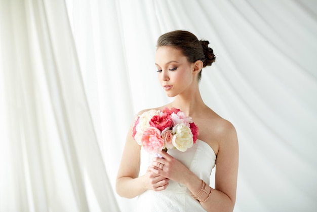 beauty, jewelry, people and luxury concept - beautiful asian woman or bride in white dress with peony flower, golden ring and bracelet