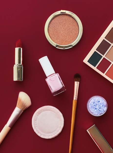 Beauty makeup and cosmetics flatlay design with copyspace cosmetic products and makeup tools on burgundy background girly and feminine style concept