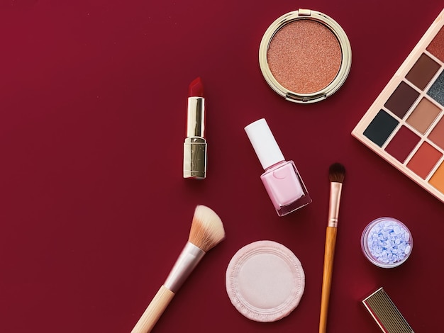 Beauty makeup and cosmetics flatlay design with copyspace cosmetic products and makeup tools on burgundy background girly and feminine style concept