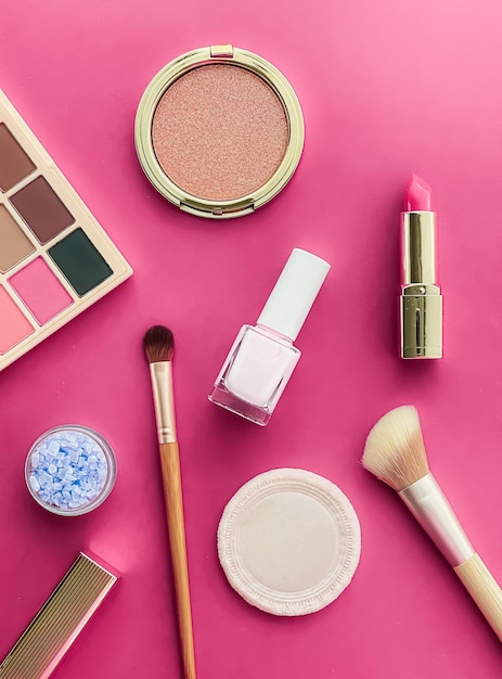 Beauty makeup and cosmetics flatlay design with copyspace cosmetic products and makeup tools on pink background girly and feminine style concept