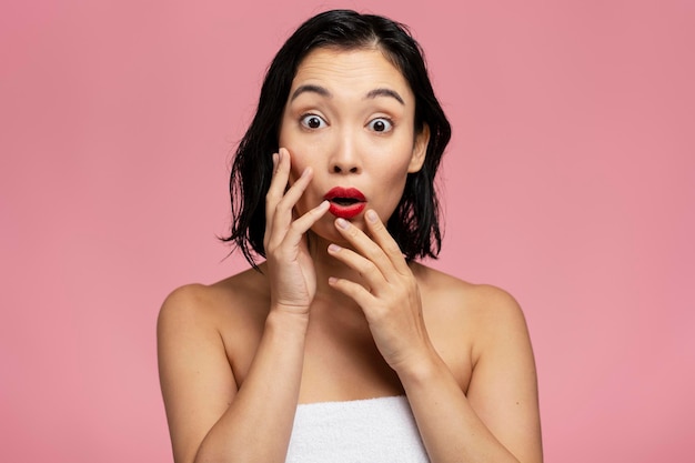 Beauty model woman with brown hair and red lips showing surprised emotions at studio