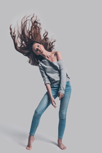 Beauty in motion. Full length studio shot of attractive young woman with tousled hair posing 