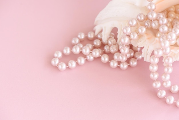 Beauty pearl beads at shell on pastel pink background