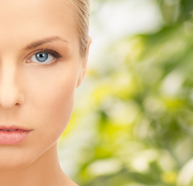 beauty, people and health concept - beautiful young woman face over green background