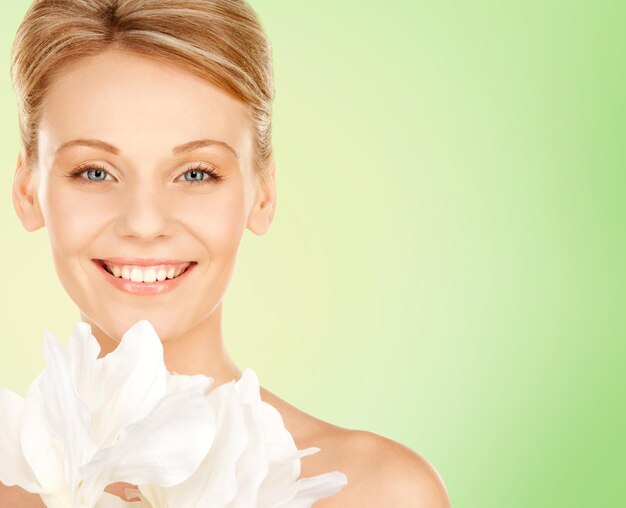 Photo beauty, people and health concept - beautiful young woman with bare shoulders over green background