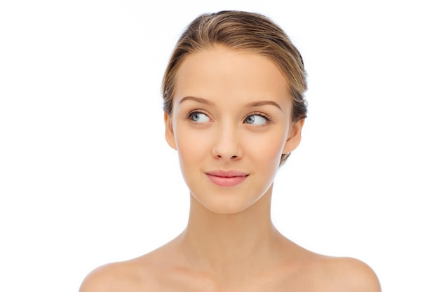 beauty, people and health concept - smiling young woman face and shoulders