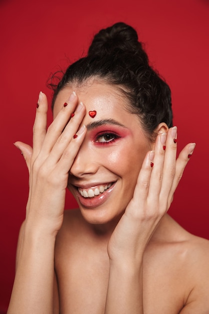 Beauty portrait of an attractive young topless woman wearing makeup standing isolated 