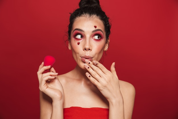 Beauty portrait of an attractive young topless woman wearing makeup standing isolated 