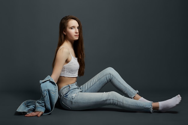 Beauty portrait of a beautiful young girl on a dark background. Cosmetics for teenagers, acne treatment