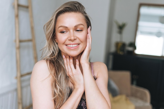 Beauty portrait of blonde smiling woman 35 year plus clean fresh face and hands