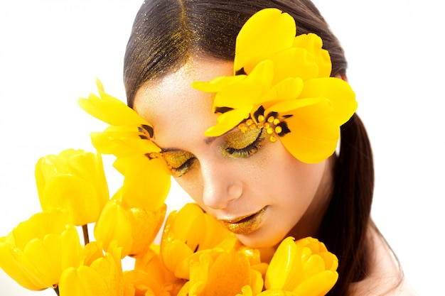 Beauty portrait of a brunette with extended eyelashes in the image of a tulip. on a white 