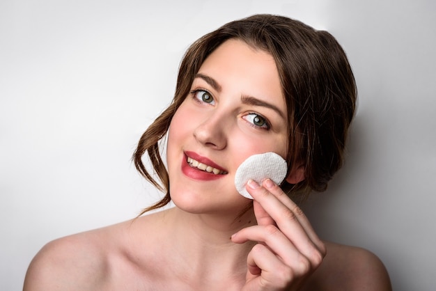 Beauty portrait of female face with natural skin on gray background.