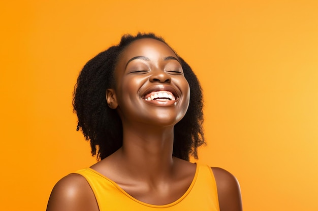 Beauty portrait of young african american woman laughing on yellow background