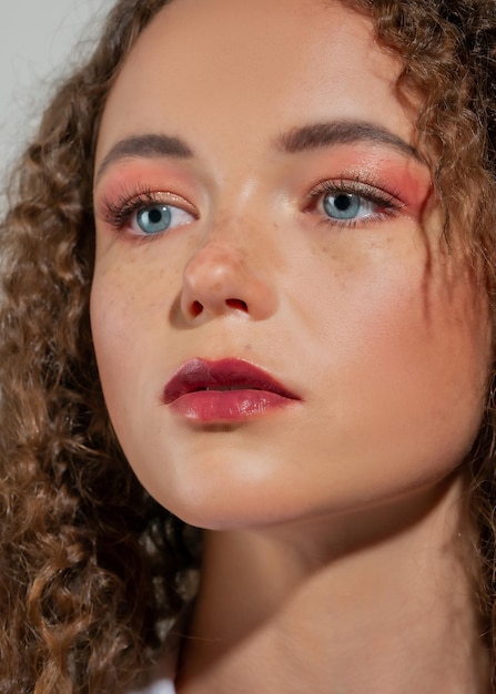 Beauty Portrait of a young girl with curly hair closeup The girl with blue eyes