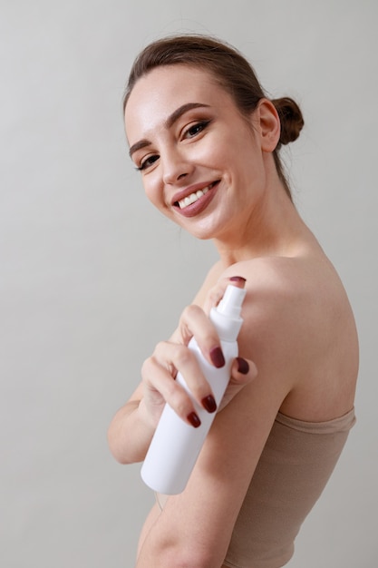  beauty portrait of a young, healthy, beautiful, fresh skinned caucasian woman on a grey wall