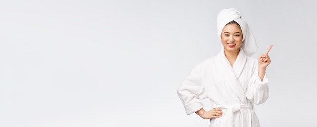 Beauty portrait of young woman showing and pointing finger to empty copy space asian beauty in bathrobe