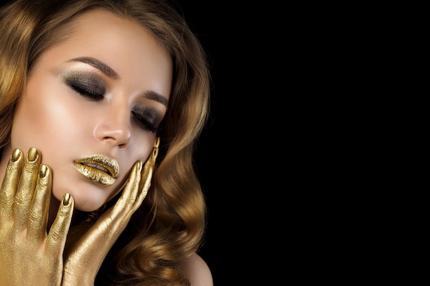 Beauty portrait of young woman with golden makeup. Smokey eyes. Sensuality, passion, trendy luxurious makeup concept. Copy space