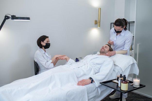 Beauty procedures. Two professionals working with the client in the beauty salon