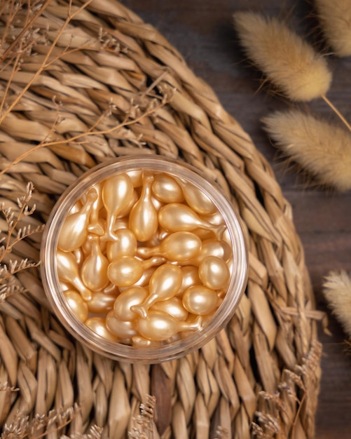 Beauty serum capsules in a jar on wattled placemat near Hare's Tail grass Cosmetic Mockup