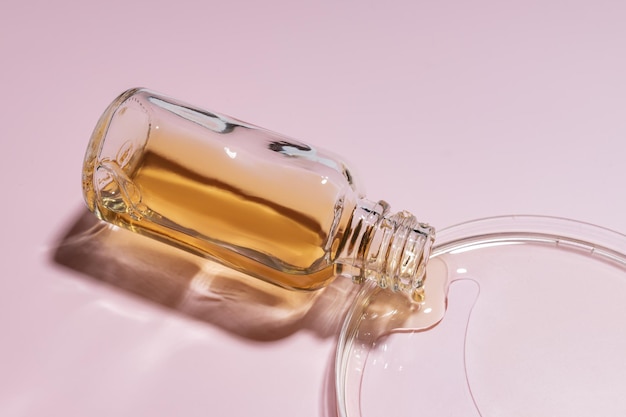 Beauty serum pours out of glass bottle into petri dish Skin care concept Testing and research