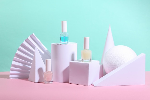 Beauty showcase Bottles of nail polish on blue pink background with geometric shapes