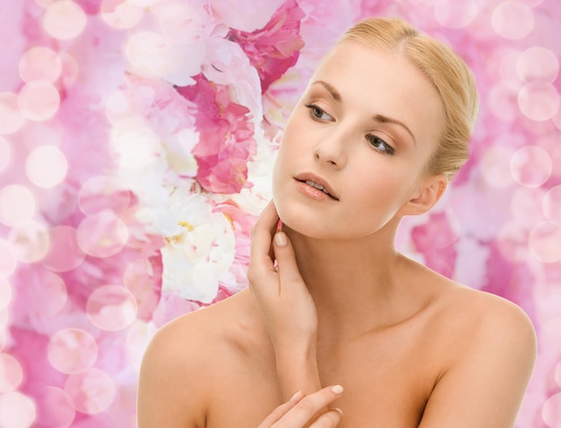 beauty and spa concept - face of beautiful woman touching her face skin