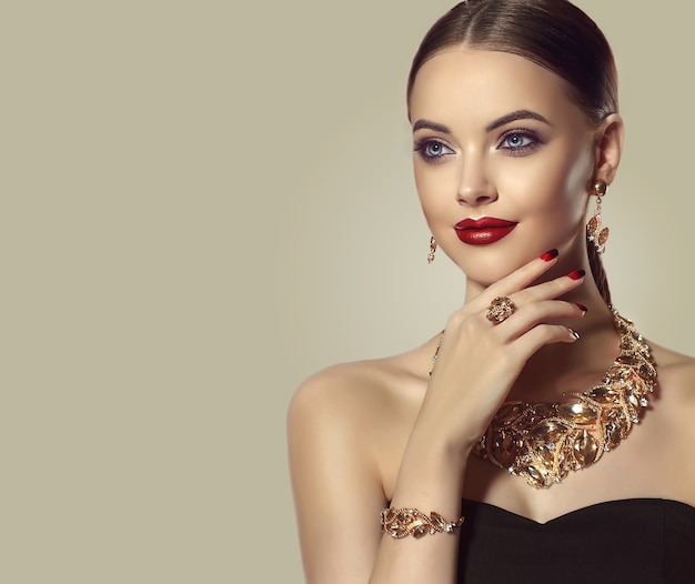 Beauty and stylePretty blue eyed model  in elegant evening makeup is smiling softly to the viewer Jewelry set of necklace ring and earrings is dressed on her