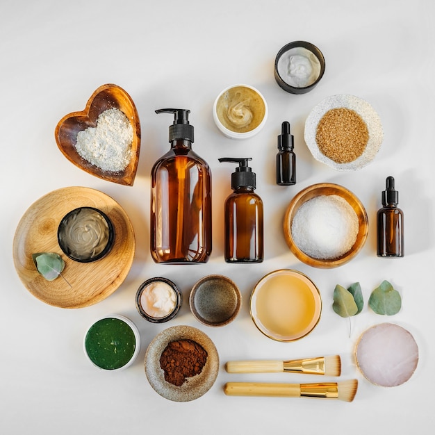 Beauty treatment ingredients for making homemade skin care cosmetic mask. Various bowl with clay, cream, essential oil and natural ingredients  on white table background. Organic spa cosmetic products