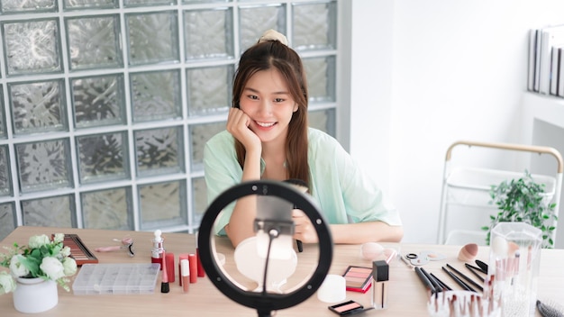 Beauty Vlogger concept Young woman introduced makeup brush and cosmetic to record video for Vlog