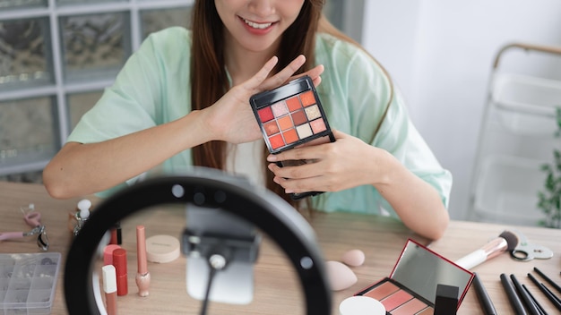 Beauty Vlogger concept Young woman show eyeshadow to presenting product and record video for Vlog