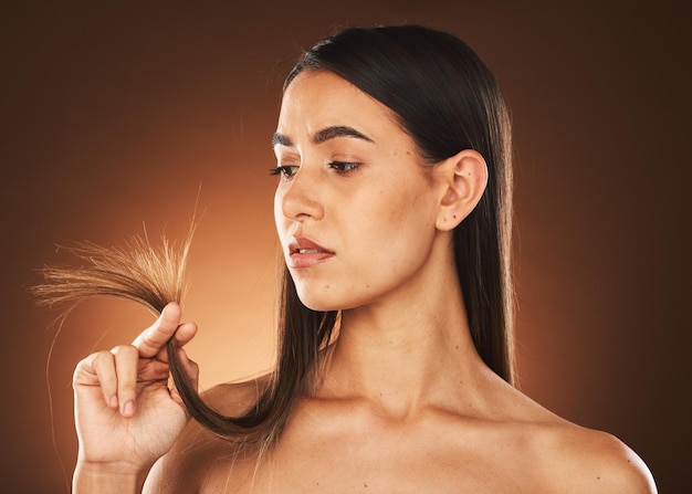 Beauty woman and hair check for growth of split ends with worried ponder and thinking face Concerned skincare body and hair care model with treatment problem on brown studio background