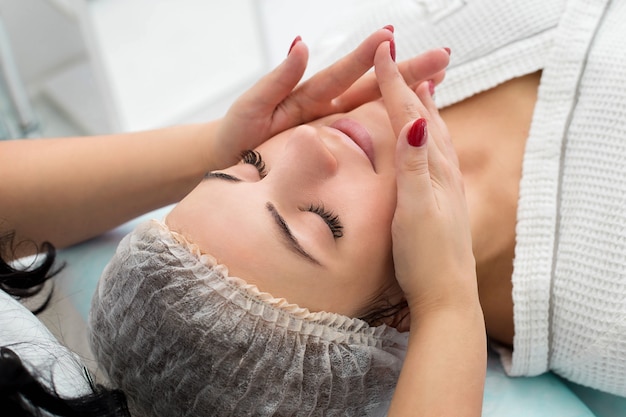 Beauty woman having cosmetic massage, facial treatment, close up.