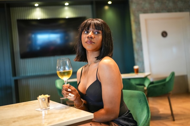 Beauty woman in night dress drinking alone in a restaurant