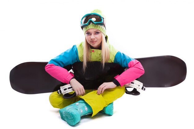 Photo beauty young woman in ski suit and ski glasses sit with sbowboard