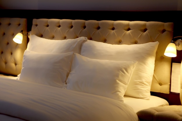 Bed made-up with white big pillows at beautiful bedroom. pillow on bed decoration in interior