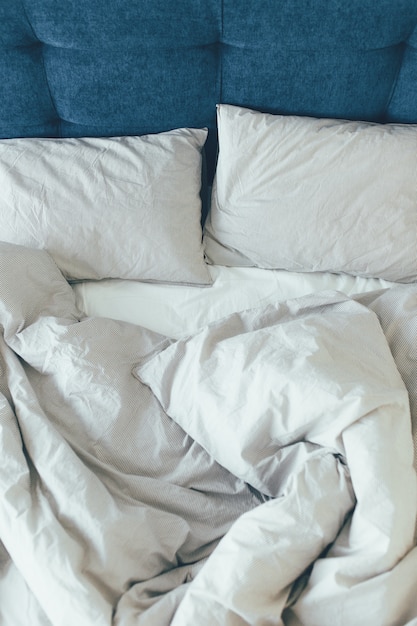 Bed maid-up with clean white pillows and bed sheets in beauty room. Close-up.