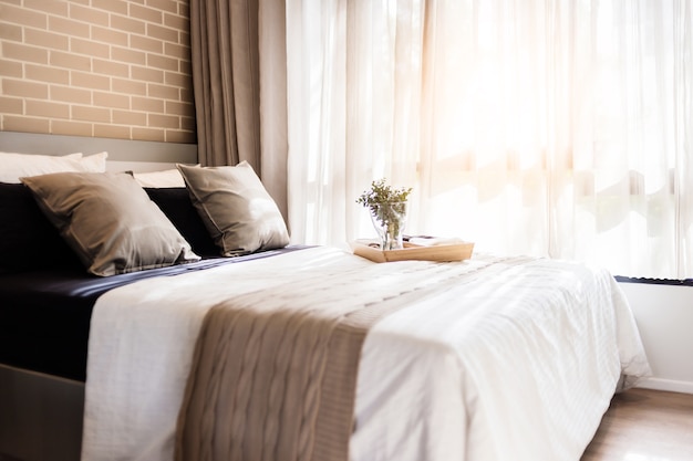 Bed maid-up with clean white pillows and bed sheets in beauty room. 