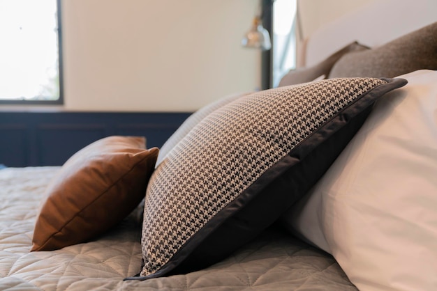 Bed maidup with clean white pillows and bed sheets in beauty room Closeup Lens flair in sunlightCloseup of new bed comforter with decorative pillows headboard in bedroom in staging at home