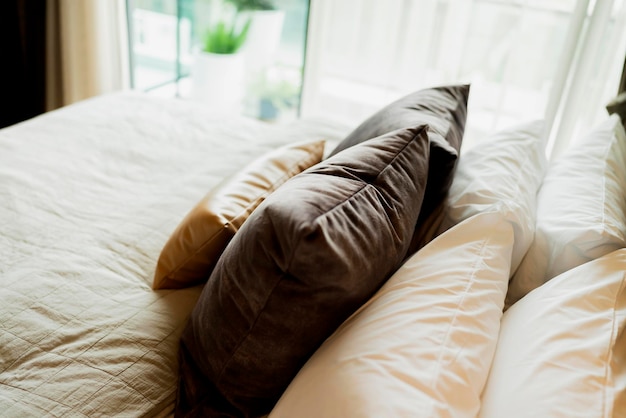 Bed maidup with clean white pillows and bed sheets in beauty room Closeup Lens flair in sunlighthome interior detail design background