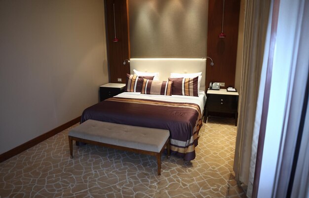 Bed with brown pillows and bedspread in hotel room