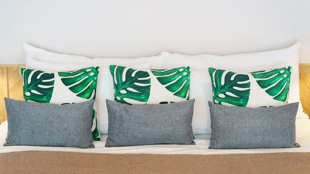 Bed with sheets and many pillows in bedroom