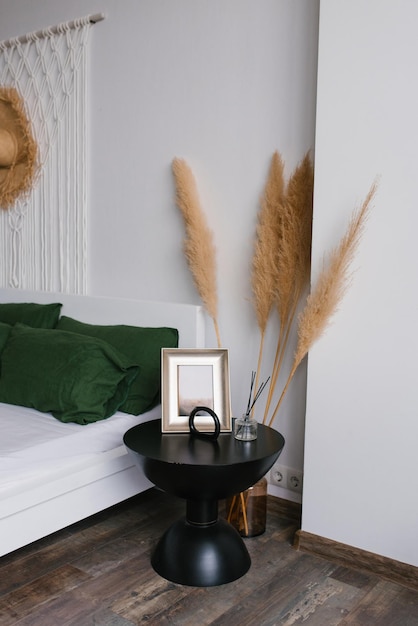 Bedroom decor in boho style Bedside table and dried flowers in a vase