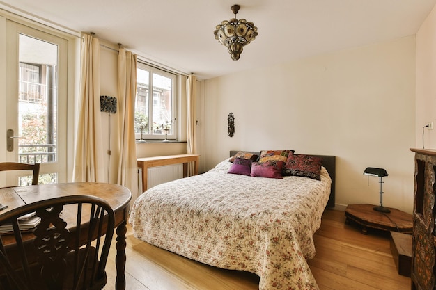 a bedroom with a bed chair and table in front of the window that looks out onto an outside patio